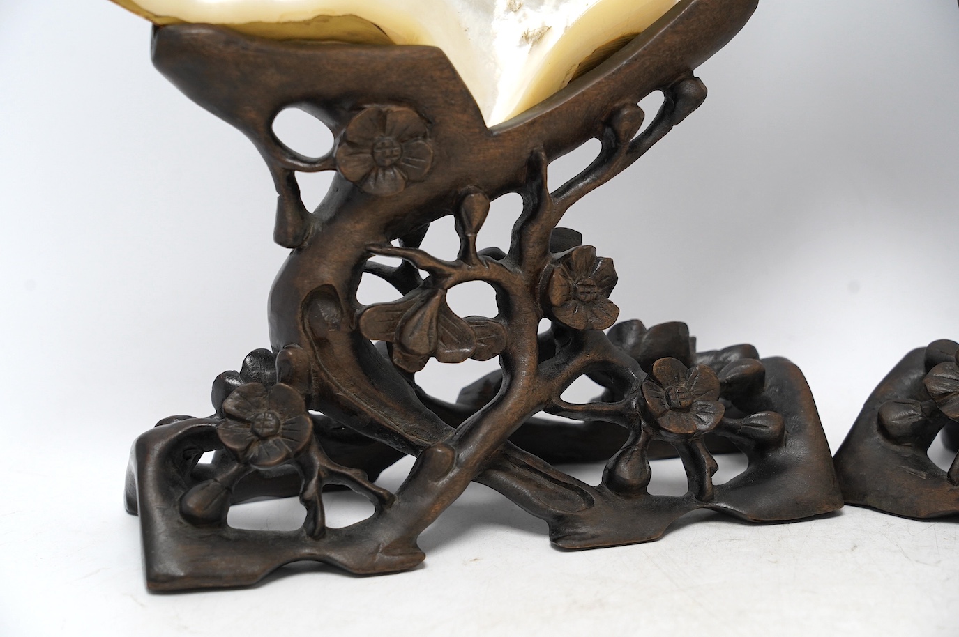 A pair of Japanese gold lacquer mother-of-pearl shells on Chinese hongmu stands, late 19th century, shells 25cm wide. Condition - fair to good